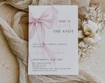 May include: A bridal shower invitation with a watercolor bow in shades of pink. The text reads "She's tying the knot" and includes details for the event, such as the date, time, location, and RSVP information. The invitation is on a white background.