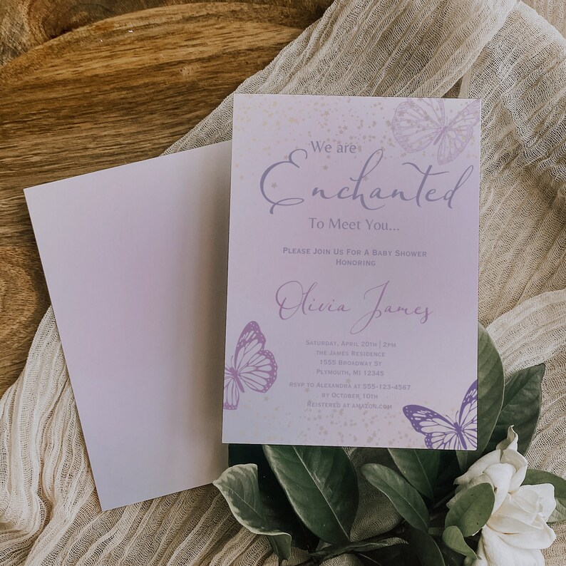 Op de afbeelding: Paarse en gouden babyborrel uitnodiging met een vlinderontwerp. De uitnodiging luidt "We are Enchanted to Meet You..." en bevat de naam "Olivia James".
