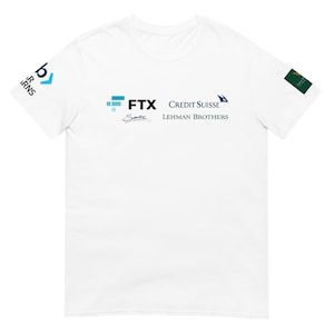 May include: White t-shirt featuring logos for FTX, Credit Suisse, Lehman Brothers, and other brands. The shirt has a crew neck and short sleeves. Logos are in blue, black, and green.