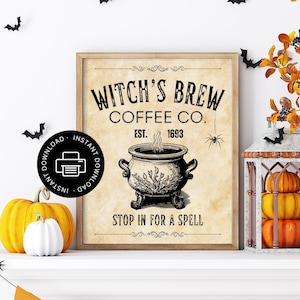 May include: A framed rectangular wall art print with a beige parchment-style background. The text reads Witch's Brew Coffee Co. Est. 1693 and Stop In For A Spell. A black and white illustration of a steaming cauldron and a spider are centred.