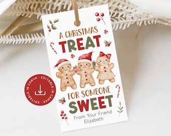 May include: A Christmas-themed gift tag with a brown leather string. The tag features the text "A Christmas Treat For Someone Sweet" and illustrations of gingerbread people wearing Santa hats. The tag also includes holly and candy cane accents.