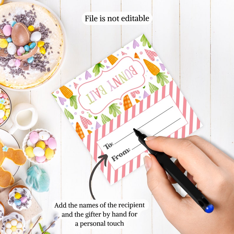 Puede incluir: Etiqueta de regalo rosa y blanca con tem&aacute;tica de conejito con un patr&oacute;n a rayas y un espacio para escribir "Para:" y "De:". La etiqueta tiene un conejito de dibujos animados y zanahorias. El texto "Bunny Bail" est&aacute; escrito en la etiqueta.