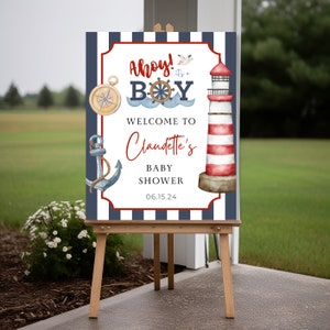 K&ouml;nnte beinhalten: Ein nautisches Babyparty-Willkommenszeichen mit blauen und wei&szlig;en Streifen, einem rot-wei&szlig;en Leuchtturm, einem Anker, einem Kompass und dem Text "Ahoy! It's a Boy. Welcome to Claudette's Baby Shower 06.15.24"