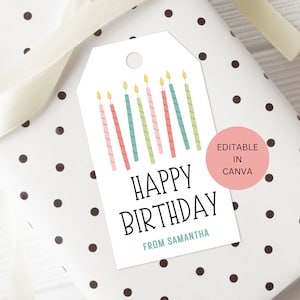 Puede incluir: Una etiqueta de regalo blanca con un diseño de velas de cumpleaños de colores. La etiqueta dice "Feliz cumpleaños" y "De parte de Samantha".
