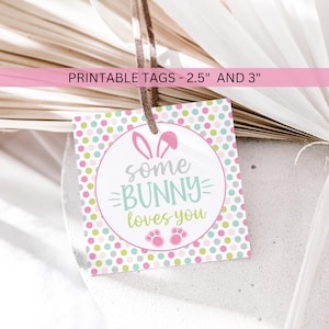 May include: Printable Easter gift tags with a pink, green, and gray polka dot background. The tags feature a circle with bunny ears and the text "some bunny loves you" in a white circle with pink paw prints.
