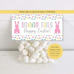 May include: A clear bag filled with white marshmallows, topped with a printable Easter bag topper. The topper features the text "BUNNY TAILS Happy Easter!" with pink bunny silhouettes and colorful hearts. The bag topper is available in three sizes: 4", 5", and 6.5".