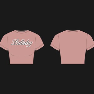 Puede incluir: Una camiseta rosa corta con mangas cortas y la palabra "Lullaby" impresa en la parte delantera en una fuente blanca de estilo cursivo.