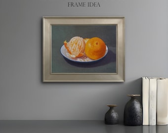 May include: A framed still life painting featuring two oranges, one peeled, on a white plate with a blue rim. The painting is set against a dark green background and framed in silver. The text "DEL ROSAL ART FRAME IDEA" is at the top.