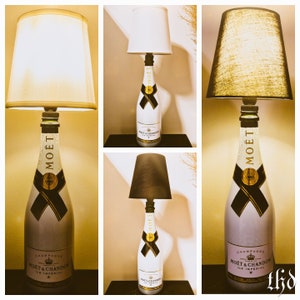 May include: Three table lamps made from champagne bottles with different colored lampshades. The bottles are labeled "Mo&euml;t & Chandon Ice Imperial" and "Mo&euml;t".