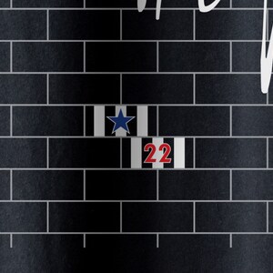 Pode incluir: Uma parede de tijolo preto e branco com uma estrela azul e o n&uacute;mero 22 em vermelho.
