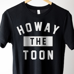 Op de afbeelding: Zwart T-shirt met witte tekst die "Howay the Toon" zegt.