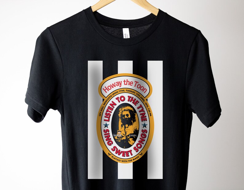 K&ouml;nnte beinhalten: Schwarzes T-Shirt mit einem wei&szlig;en Streifenmuster. Ein gelber Kreis mit rotem und wei&szlig;em Text lautet "Howay the Toon City Hall Newcastle Upon Tyne, Tuesday, 13th April, 1972, 7:30 PM Listen to the Tyne Sing Sweet Songs Playing with the Mads"