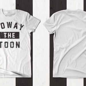 May include: White t-shirt with a black graphic print that says "Howay The Toon". The shirt is shown on a black and white striped background.