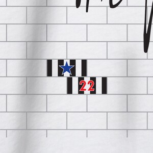 Pode incluir: Uma parede de tijolo branco com listras pretas e brancas e uma estrela azul. O n&uacute;mero 22 est&aacute; escrito em vermelho nas listras.
