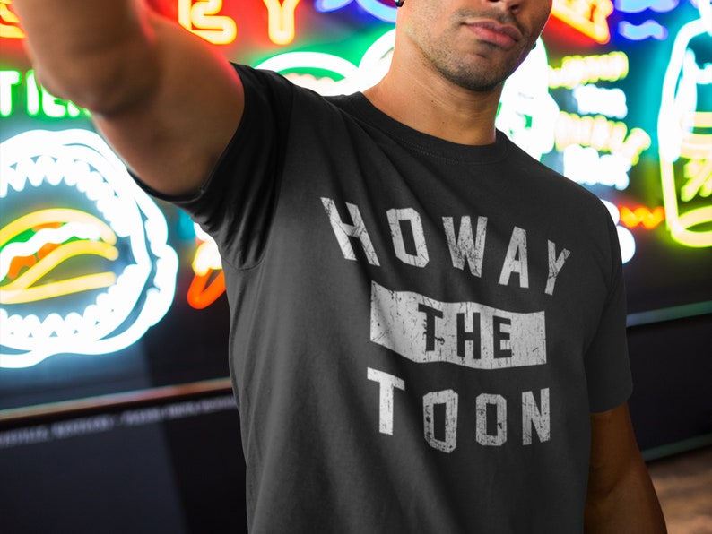May include: A black t-shirt with white text that reads "HOWAY THE TOON". The text has a distressed, vintage look.