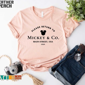 a t - shirt that says please return to mickey & co main street, usa