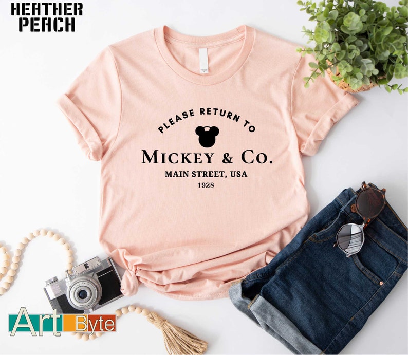 a t - shirt that says please return to mickey & co main street, usa