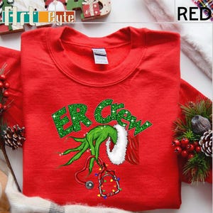 a red t - shirt with the grin on it