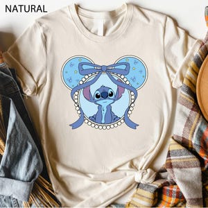 a t - shirt with a picture of a baby elephant wearing a bow
