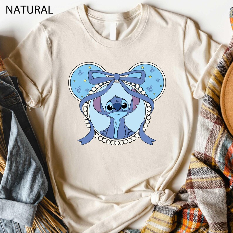 a t - shirt with a picture of a baby elephant wearing a bow