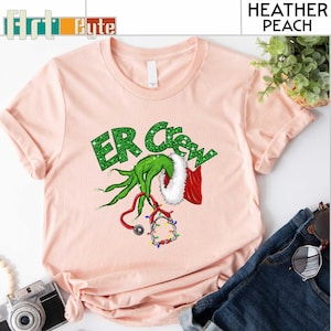 a pink shirt with a green grin on it