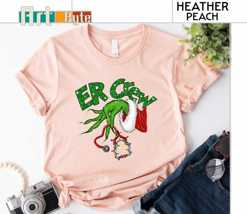 a pink shirt with a green grin on it