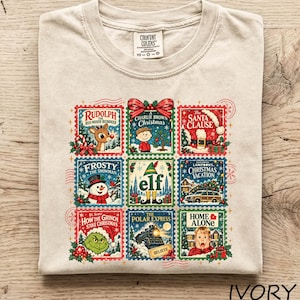 May include: An ivory t-shirt featuring a grid of nine postage stamp-style illustrations of classic Christmas films including Rudolph, A Charlie Brown Christmas, The Santa Clause, Frosty the Snowman, Elf, Christmas Vacation, The Grinch, The Polar Express, and Home Alone.