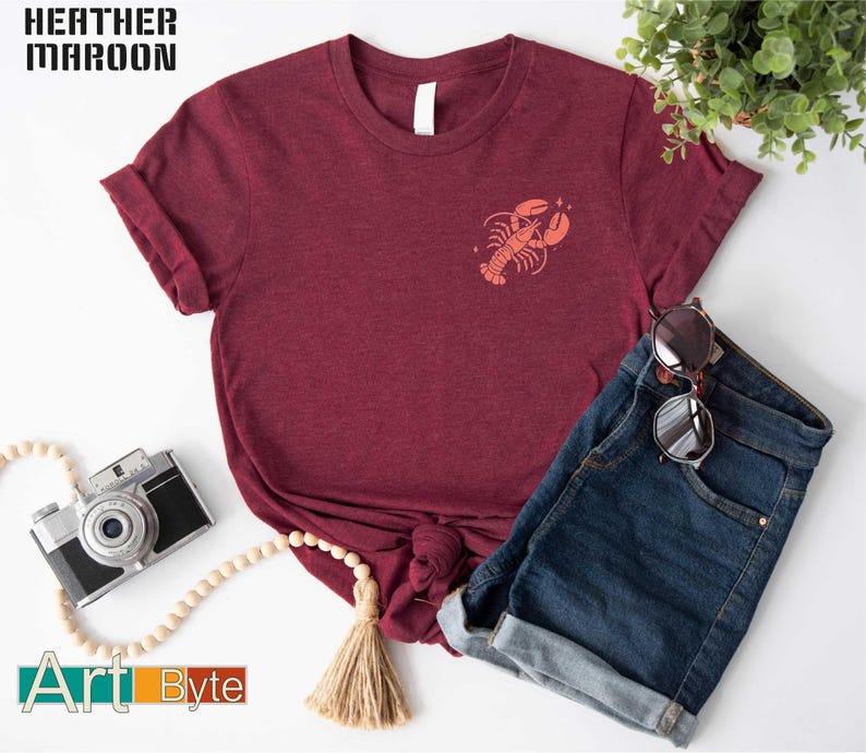 a t - shirt with a crab on it next to a pair of jeans and