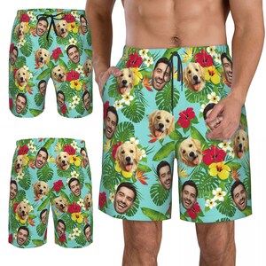 Puede incluir: Un par de pantalones de ba&ntilde;o azules con un estampado tropical que presenta un patr&oacute;n repetitivo de caras, perros y flores.