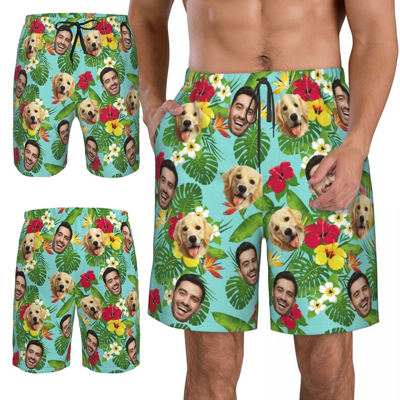 Puede incluir: Un par de pantalones de ba&ntilde;o azules con un estampado tropical que presenta un patr&oacute;n repetitivo de caras, perros y flores.