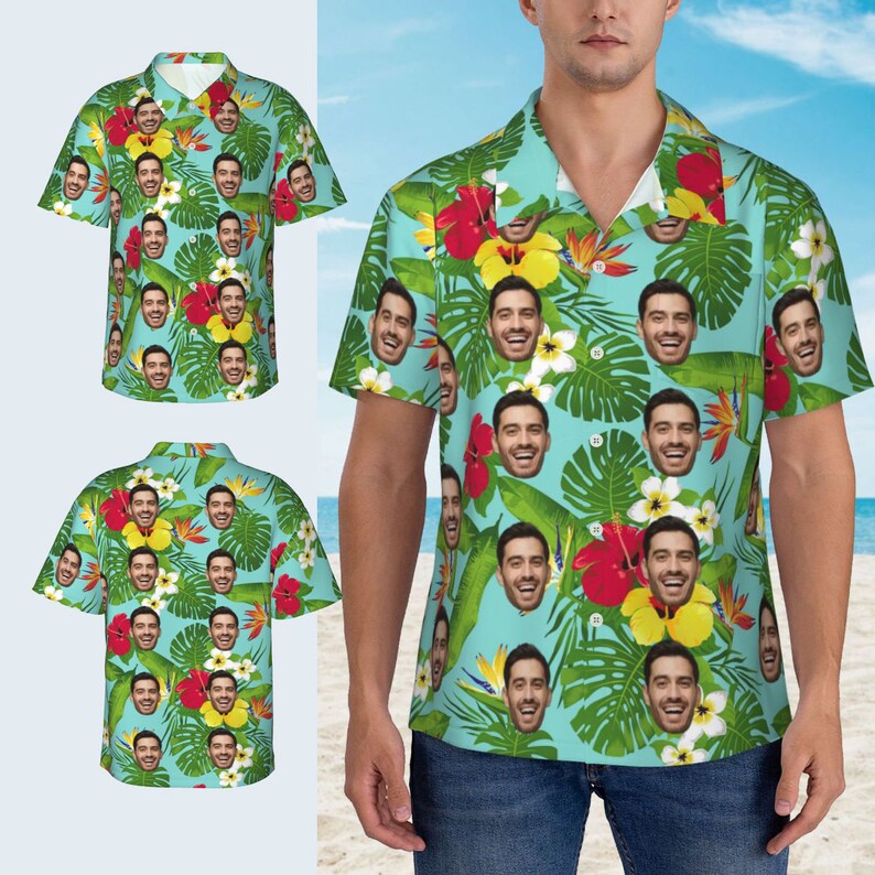 Puede incluir: Una camisa de manga corta de color azul claro con botones y un estampado tropical que presenta un patr&oacute;n repetido de un rostro de hombre, hojas verdes y flores rojas, amarillas y blancas.