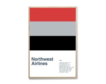 May include: A framed print featuring a minimalist design with horizontal bands of red, gray, and black. The text "Northwest Airlines" is below the bands, with a list of hubs. The print is in a light wood frame.