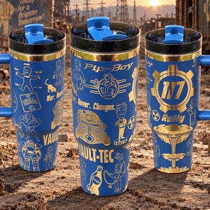 May include: Three blue travel tumblers with black lids and blue flip-top closures. The tumblers feature gold-colored graphics including the text Pip-Boy, Vault-Tec, 117, and War. Never. Changes., along with various character illustrations and icons.