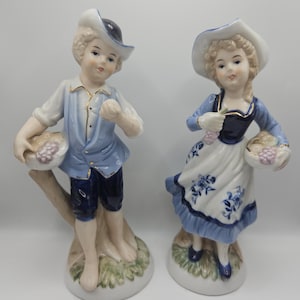 two porcelain figurine boy and girl with fruit baskets