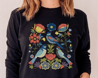 May include: A black long-sleeved sweatshirt with a colorful floral and bird design. The design features blue, red, yellow, green, and white colors.