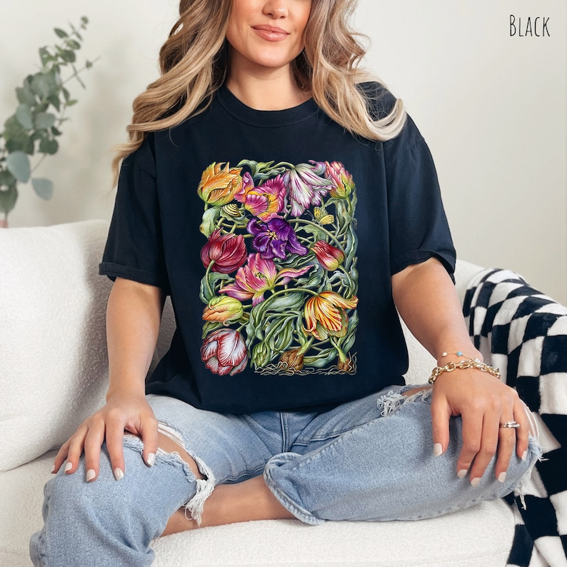Op de afbeelding: Zwart T-shirt met een kleurrijke bloemenprint van tulpen. De print bevat een verscheidenheid aan kleuren, waaronder roze, paars, geel en oranje.