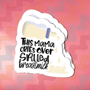 May include: A white sticker with a whimsical design and the text "THIS MAMA CRIES OVER SPILLED breastmilk." The design includes a cartoon bottle pouring out milk. The background is a watercolor wash of pink and peach.