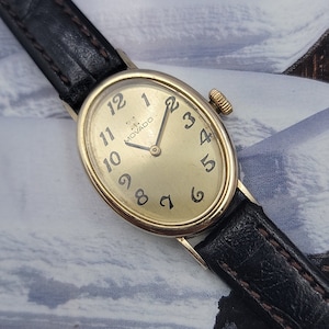 This vintage Movado wristwatch is a stunning piece for any woman's collection. The oval case is made of yellow gold and features a manual wi