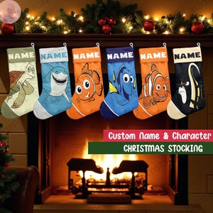 May include: Six Christmas stockings with character designs, including a turtle, shark, and clownfish, hang above a fireplace. Each stocking has a white cuff with the word "NAME" and a personalized name area. The text "Custom Name & Character CHRISTMAS STOCKING" is below.