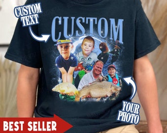 May include: A dark navy blue short-sleeve t-shirt featuring a custom graphic print. The design includes the word CUSTOM in large light blue letters, surrounded by multiple photographic images of people fishing with large fish, and text labels.