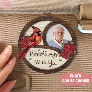 May include: A wooden car sunshade with a photo frame, a cardinal bird, and red poinsettia flowers. The text "I'm Always With You" is written on the sunshade.