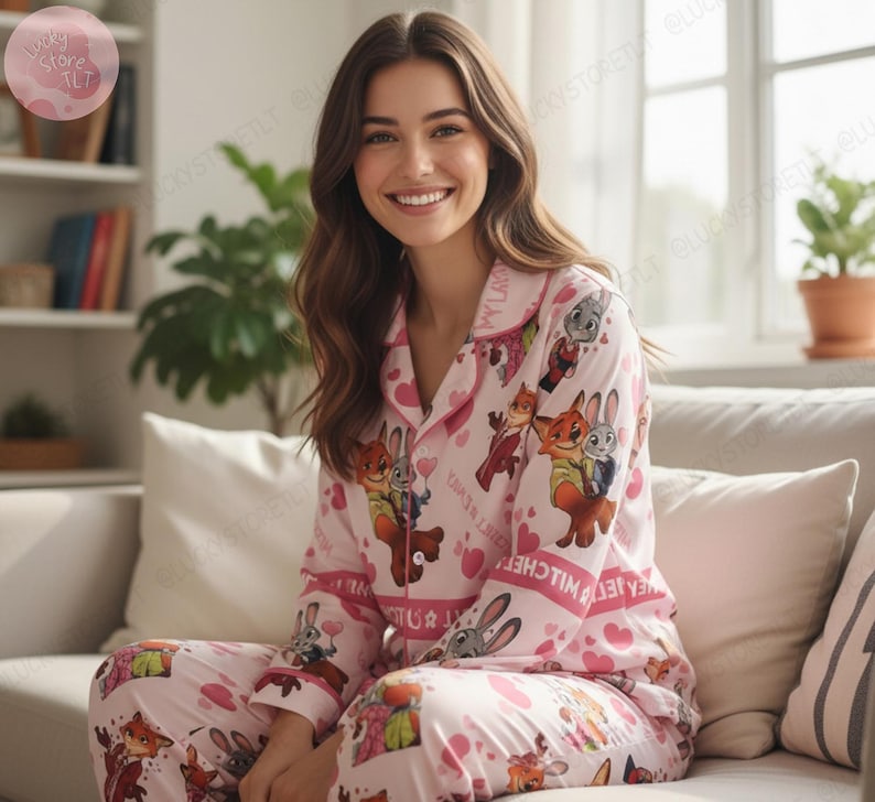 K&ouml;nnte beinhalten: Rosa Pyjama-Set mit Cartoon-Figuren und Herzmustern. Das lang&auml;rmlige Oberteil hat einen Kragen und eine Knopfleiste. Die passende Hose vervollst&auml;ndigt das Set und sorgt f&uuml;r ein bequemes und koordiniertes Nachtw&auml;sche-Ensemble.