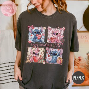 Puede incluir: Camiseta gris oscuro con un dise&ntilde;o de cuatro paneles con los personajes Stitch y Angel sosteniendo corazones y regalos. Las palabras "Happy Valentine's Day" est&aacute;n impresas en la camiseta. La camiseta es de color pimienta.
