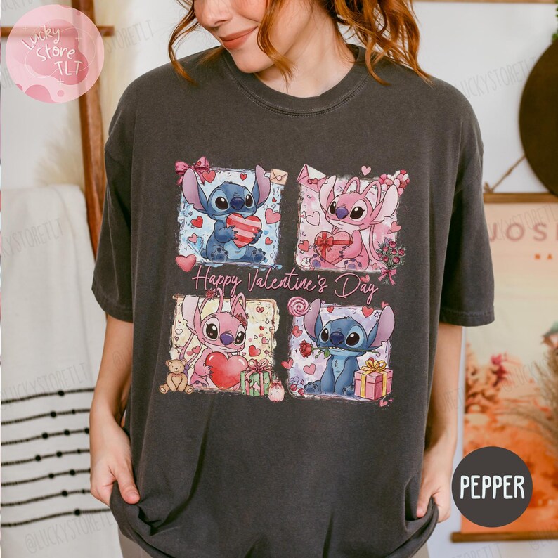 Puede incluir: Camiseta gris oscuro con un dise&ntilde;o de cuatro paneles con los personajes Stitch y Angel sosteniendo corazones y regalos. Las palabras "Happy Valentine's Day" est&aacute;n impresas en la camiseta. La camiseta es de color pimienta.