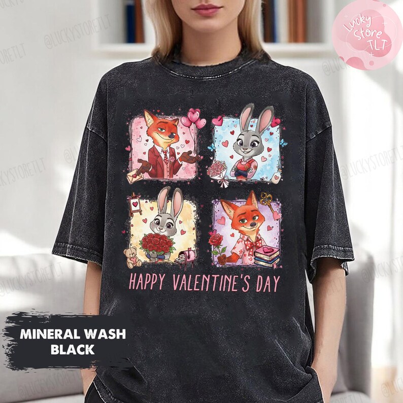 Pu&ograve; includere: T-shirt nero lavato con un motivo colorato con personaggi dei cartoni animati e la scritta "HAPPY VALENTINE'S DAY". Il design include una volpe e un coniglio in ambientazioni romantiche. La maglietta ha anche la scritta "MINERAL WASH BLACK".