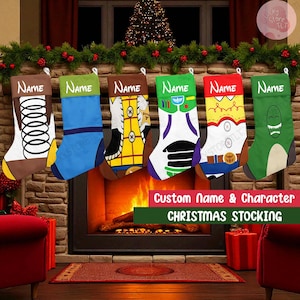 Op de afbeelding: Zes kerstsokken met karakterontwerpen hangen boven een open haard. Elke sok heeft een ander ontwerp, waaronder een veer, een blauwe outfit, een cowboy, een ruimteranger, een kroon en een dinosaurus. De tekst "Custom Name & Character CHRISTMAS STOCKING" is zichtbaar.