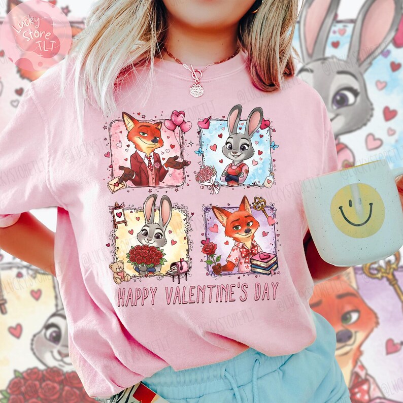 Pu&ograve; includere: T-shirt rosa chiaro con un design di San Valentino. Il design presenta personaggi dei cartoni animati, una volpe e un coniglio, con cuori e fiori. Il testo "Happy Valentine's Day" &egrave; stampato sotto.
