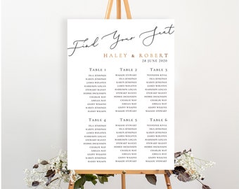 May include: A white wedding seating chart with black text on an easel. The chart lists guest names and table numbers for a wedding reception. The text at the top reads "Find Your Seat" with the names Haley & Robert and the date 28 June 2020.