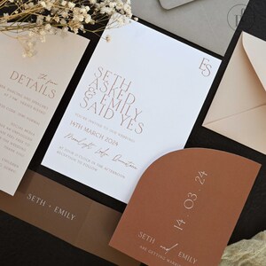 May include: A wedding invitation suite with a white background and brown accents. The invitation features the text "Seth asked & Emily said yes" in a modern font. The date of the wedding is listed as "14th March 2024" and the location is "Moonlight Ledge, Queenstown".