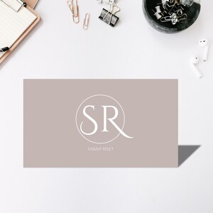 May include: A light brown business card with a white circle containing the letters "SR" and the text "SARAH RILEY" below the circle.